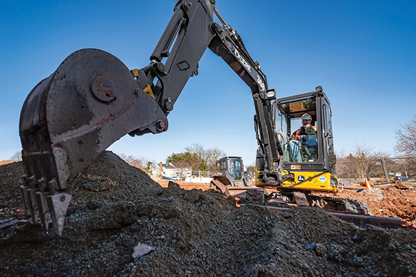 A John Deere Compact Excavator digging up dirt